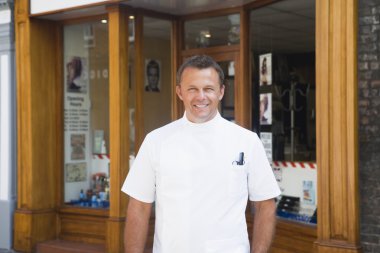 Barber standing outside shop. clipart