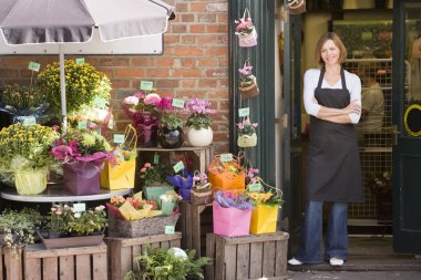Woman working at flower shop smiling clipart