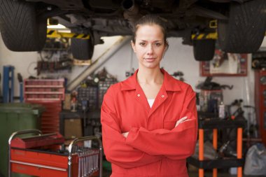 Mechanic standing in garage clipart