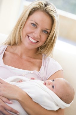 Mother in living room with baby smiling clipart