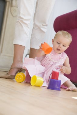 Mother in living room with baby playing clipart