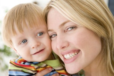 Mother and young boy indoors smiling clipart