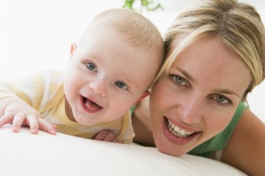 Mother and baby indoors smiling clipart