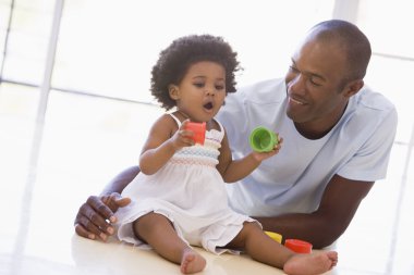 Father and daughter indoors playing and smiling clipart