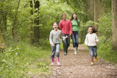 Family walking on path holding hands smiling clipart