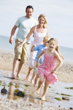 Family running at beach smiling clipart