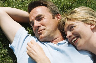 Couple lying outdoors smiling clipart