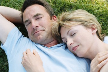 Couple lying outdoors sleeping clipart