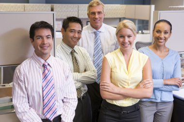 Business team standing in cubicle smiling clipart