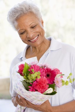 Woman holding flowers and smiling clipart