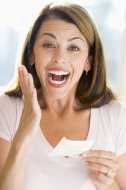 Woman with winning lottery ticket excited and smiling clipart