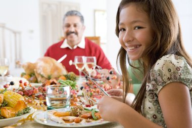 Grandfather And Granddaughter Sitting Down For Christmas Dinner clipart