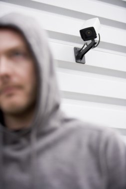 Surveillance Camera And Young Man In Hooded Sweatshirt clipart