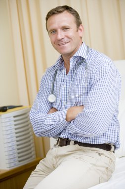 A Doctor Sitting On A Hospital Bed clipart