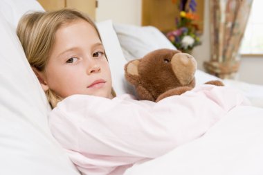 Young Girl Lying In Hospital Bed With Teddy Bear clipart