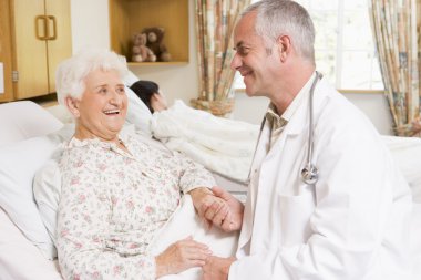 Doctor Laughing With Senior Woman In Hospital clipart