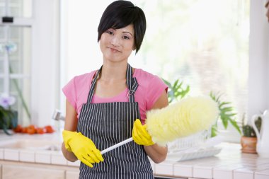 Woman Holding Duster And Wearing Rubber Gloves clipart