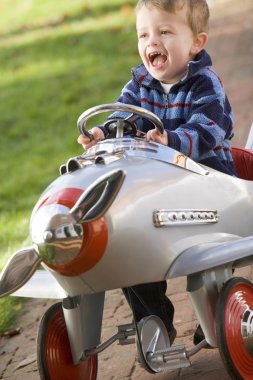 Young boy playing outdoors in airplane smiling clipart