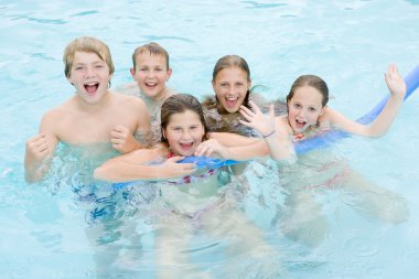 Five young friends in swimming pool playing and smiling clipart