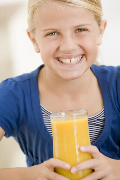 Mladá dívka, popíjeli pomerančový džus s úsměvem — Stock fotografie