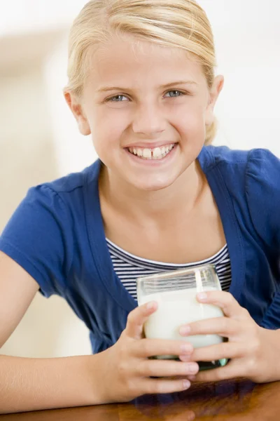 Genç kız içeride süt gülümseyen içme — Stok fotoğraf