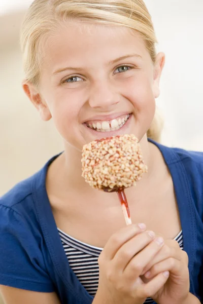 Chica Joven Interior Comiendo Caramelo Manzana Sonriendo —  Fotos de Stock