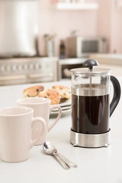 Coffee pot on kitchen counter with scones — Stock Photo, Image