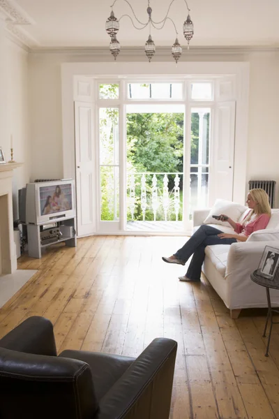 Vrouw in woonkamer televisie kijken — Stockfoto