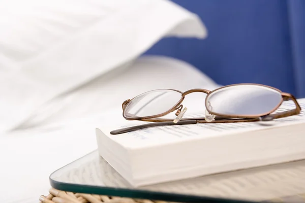 stock image Empty bedroom with focus on eyeglasses and book