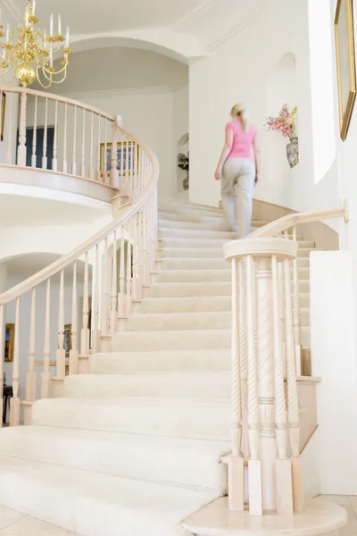 Mulher subindo escadas em casa de luxo — Fotografia de Stock