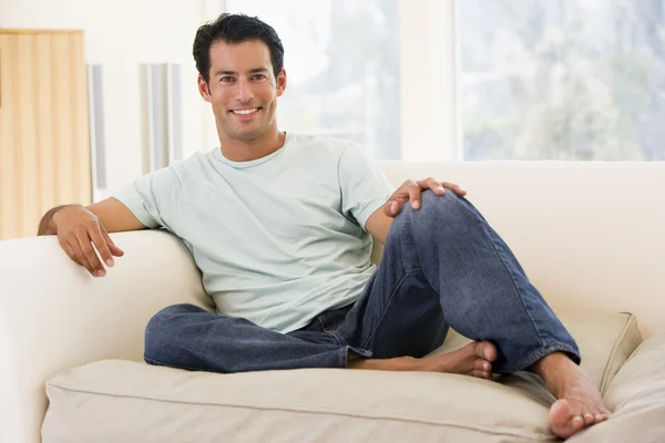 Oturma odası gülümseyerek oturan adam — Stok fotoğraf