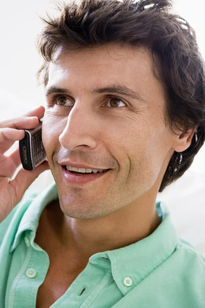 Man using cellular phone and smiling — Stock Photo, Image