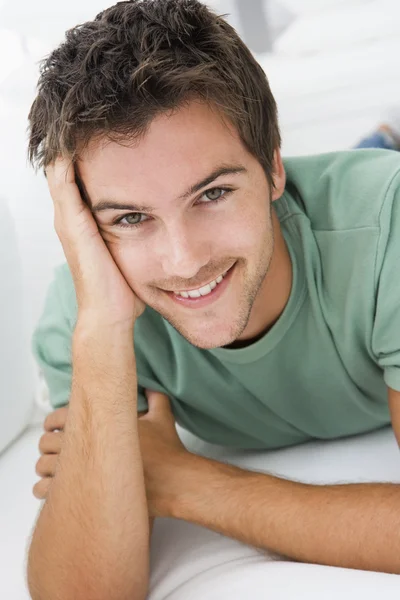Hombre acostado en la sala de estar sonriendo — Foto de Stock