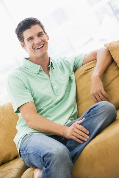 Muž sedí v obývacím pokoji směje — Stock fotografie