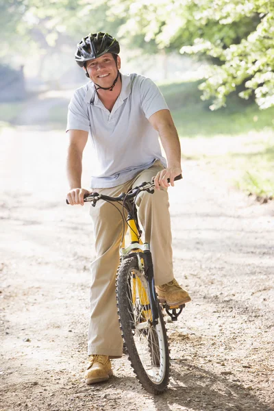 Человек на улице на велосипеде улыбается — стоковое фото