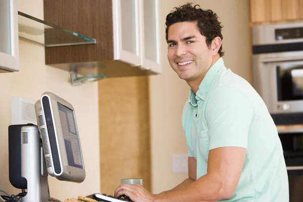 Άνθρωπος Στην Κουζίνα Χρησιμοποιώντας Υπολογιστή Και Χαμογελαστός — Φωτογραφία Αρχείου