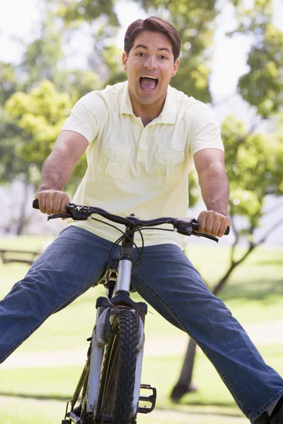 Uomo all'aperto in bicicletta con le gambe fuori — Foto Stock