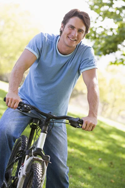 stock image Man outdoors on bike smiling