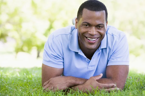 Muž ležící venku s úsměvem — Stock fotografie