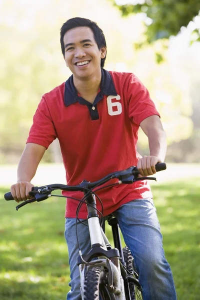 Man outdoors on bike smiling — Stock Photo, Image