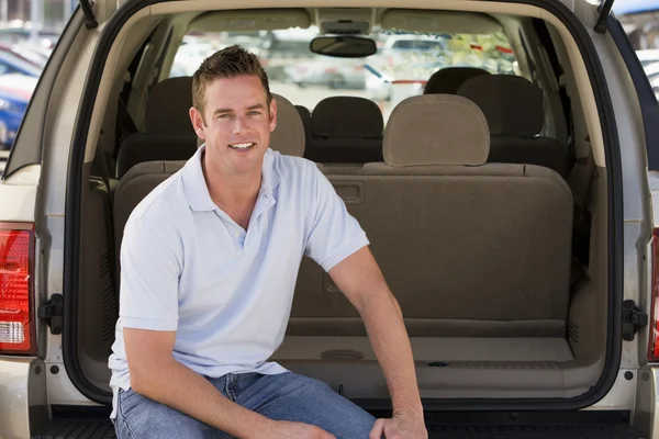Человек, сидящий на заднем сиденье фургона и улыбающийся — стоковое фото