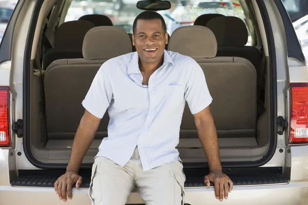 Człowiek siedzi w tył van uśmiechający się — Zdjęcie stockowe