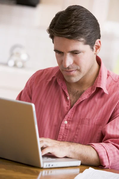 Człowiek w kuchni korzysta z laptopa — Zdjęcie stockowe