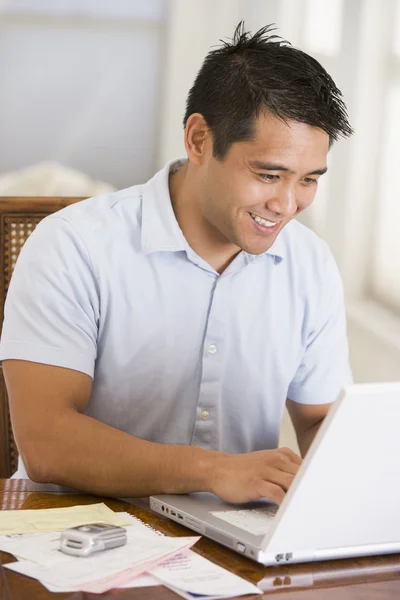 Muž v jídelně pomocí přenosného počítače a s úsměvem — Stock fotografie