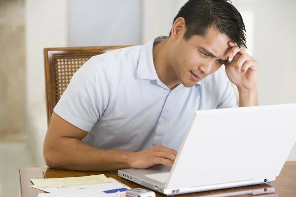 Άνθρωπος στην τραπεζαρία χρησιμοποιώντας φορητό υπολογιστή και frowning — Φωτογραφία Αρχείου