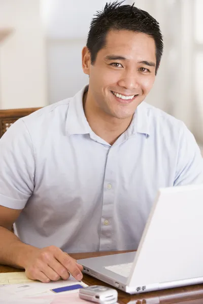 Чоловік в їдальні за допомогою ноутбука посміхається — стокове фото
