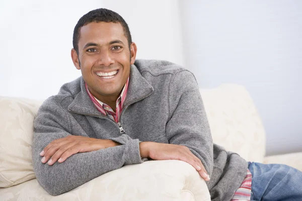 Hombre sentado en la sala de estar sonriendo — Foto de Stock