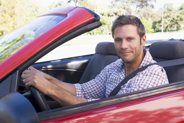 Man in een convertible auto glimlachen — Stockfoto
