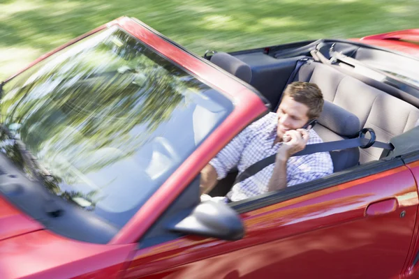 Mężczyzna Jazdy Cabrio Samochód Przy Użyciu Telefonu Komórkowego Uśmiechając Się — Zdjęcie stockowe