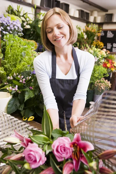 Frau, die im Blumenladen arbeitet, lächelt — Stockfoto